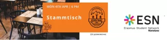 In the immage you can see the inside of a restaurant with tables and chairs. There is also a banner with Stammtisch written on it