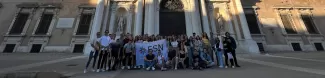 International students posing with the Flag of ESN Modena