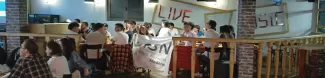 International students posing with the Flag of ESN Modena