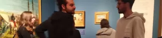 People at the museum with paintings in the background