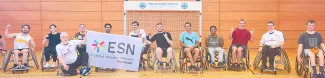 Picture of some of the participants posing in their wheelchairs in front of the hanball goal.