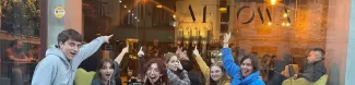 A group of international students in front of a coffee shop