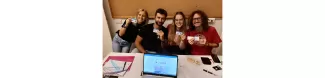 The event manager, the treasurer, the president and a staff member are in a the ESN Ravenna's stand and posing for a picture with their ESNCard