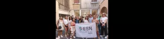 Group picture with the ESN Venezia flag standing near a fountain with a statue