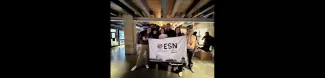Group picture of the volunteers and the international students holding the ESN Venezia flag in front of the swapping area