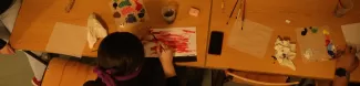 A student painting blind folded