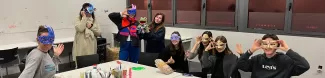 Group of international students showing off the masks they created during the activity