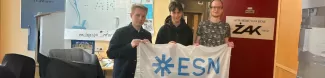 The image shows participants of the event holding the ESN-EYE flag inside the Radio Żak station.