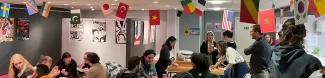 group of students talking under flags