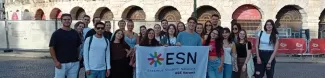 Group picture with the flag in front of the Arena