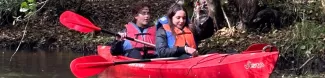 Two participants collecting trash from the river