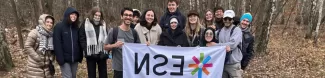 A group of students holding an ESN UŁ flag.