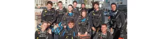 Students dressed in wetsuits with diving gear