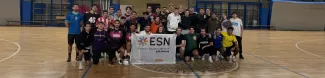 Group picture of the partecipants on the football field holding the ESN flag