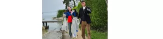 Two volunteers picking up litter by the lake.