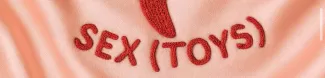 Sex(toys) written in red on light pink silk background.