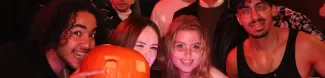 People in the Halloween party with a pumpkin